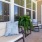 a patio with a plant and chairs